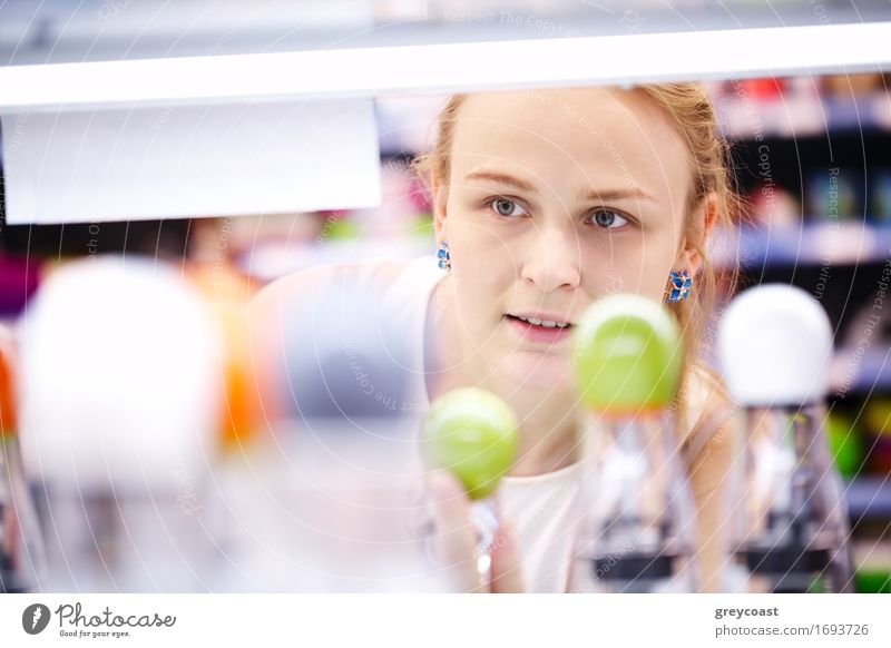 Young blond woman carefully analyzing products in a store - view through products Shopping Young woman Youth (Young adults) Woman Adults 1 Human being