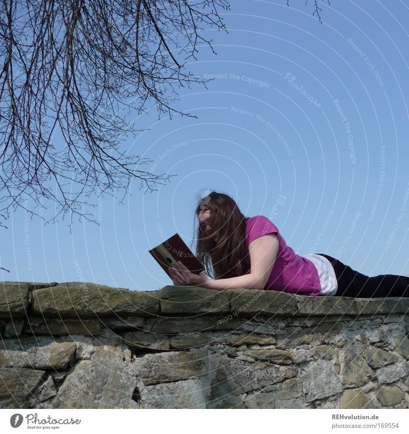 woman reading on a wall Colour photo Copy Space top Day Contentment Relaxation Calm Leisure and hobbies Reading Feminine Young woman Youth (Young adults) 1