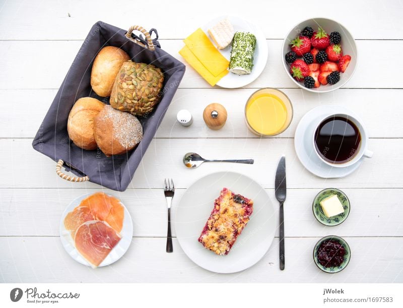 delicate breakfast at a white table with different ingredients Food Sausage Fish Cheese Yoghurt Dairy Products Fruit Dough Baked goods Roll Cake Jam Breakfast
