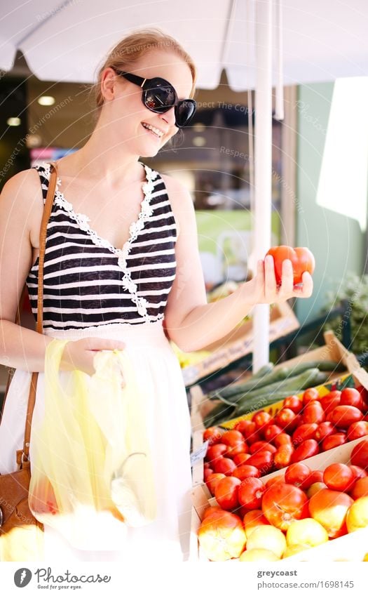 Young woman shopping for fresh tomatoes at an open-air stall choosing items from a row of wooden boxes Vegetable Fruit Apple Grain Shopping Youth (Young adults)