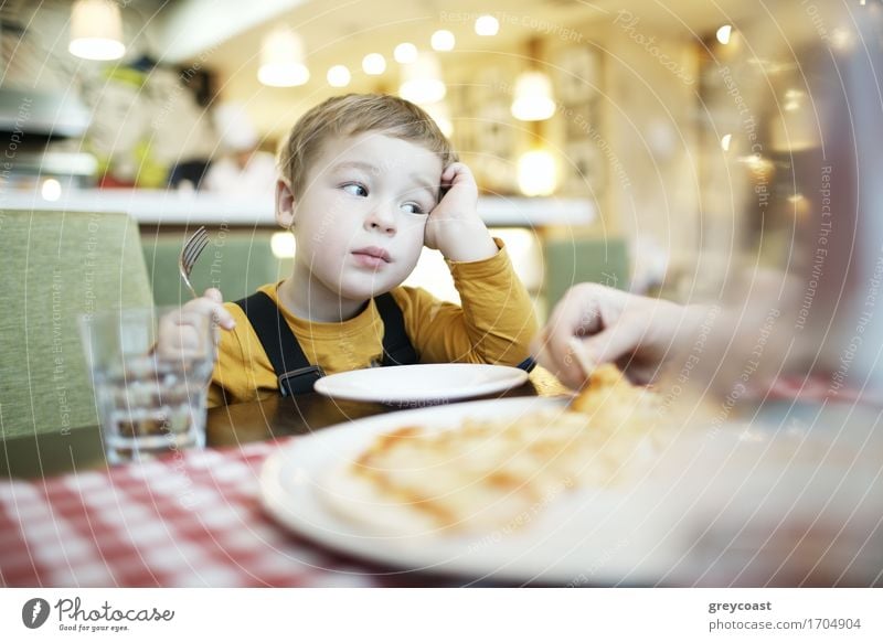 Bored little boy in a restaurant sitting with an empty plate in front of him sitting with his head resting on his hand Nutrition Eating Lunch Dinner Diet Plate