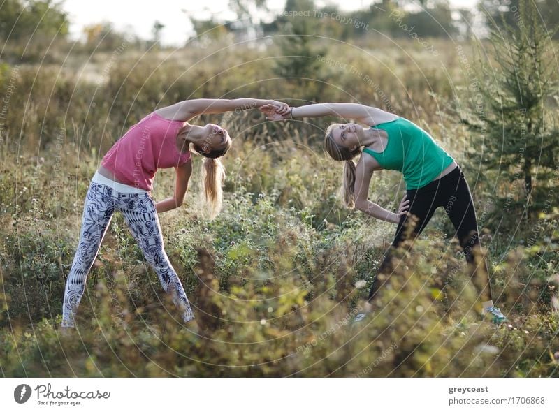 Two supple athletic young women working out together in the countryside doing bending and stretching exercises Beautiful Relaxation Sports Jogging Yoga Girl