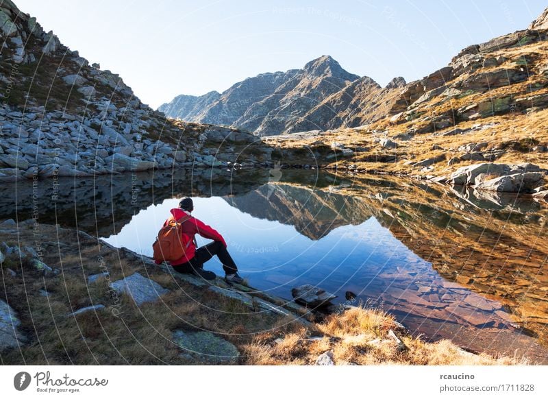 Male hiker takes a rest sitting next a mountain lake. Meditation Vacation & Travel Tourism Trip Adventure Expedition Summer Mountain Sports Human being Man