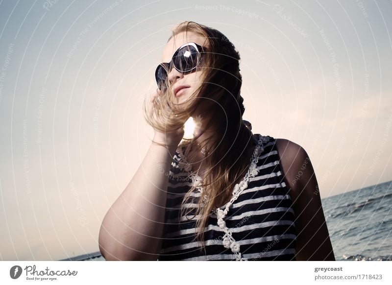 Smiling young woman in sunglasses talking on the phone and sun shines behind her back. Lifestyle Happy Beautiful Face Relaxation Vacation & Travel Summer Sun