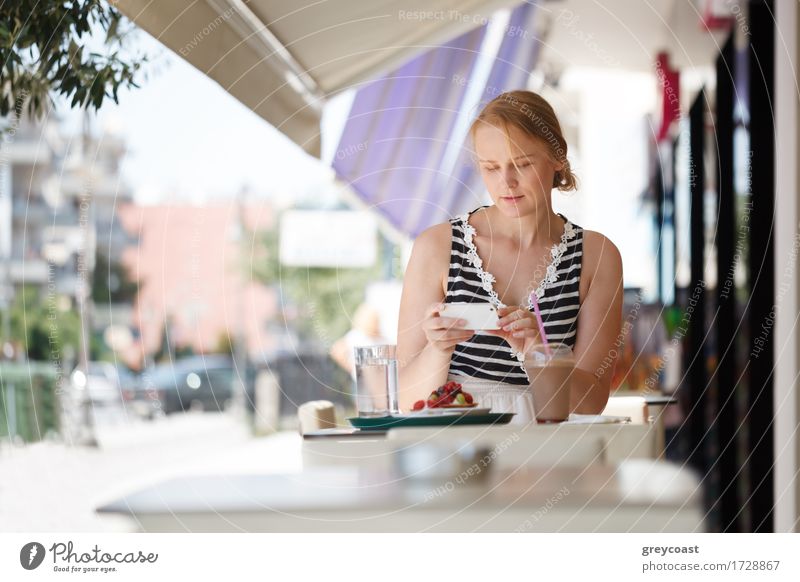 Young woman using her smartphone sitting in outdoor cafe Lunch Dinner Summer Telephone PDA Human being Girl Youth (Young adults) 1 18 - 30 years Adults Blonde