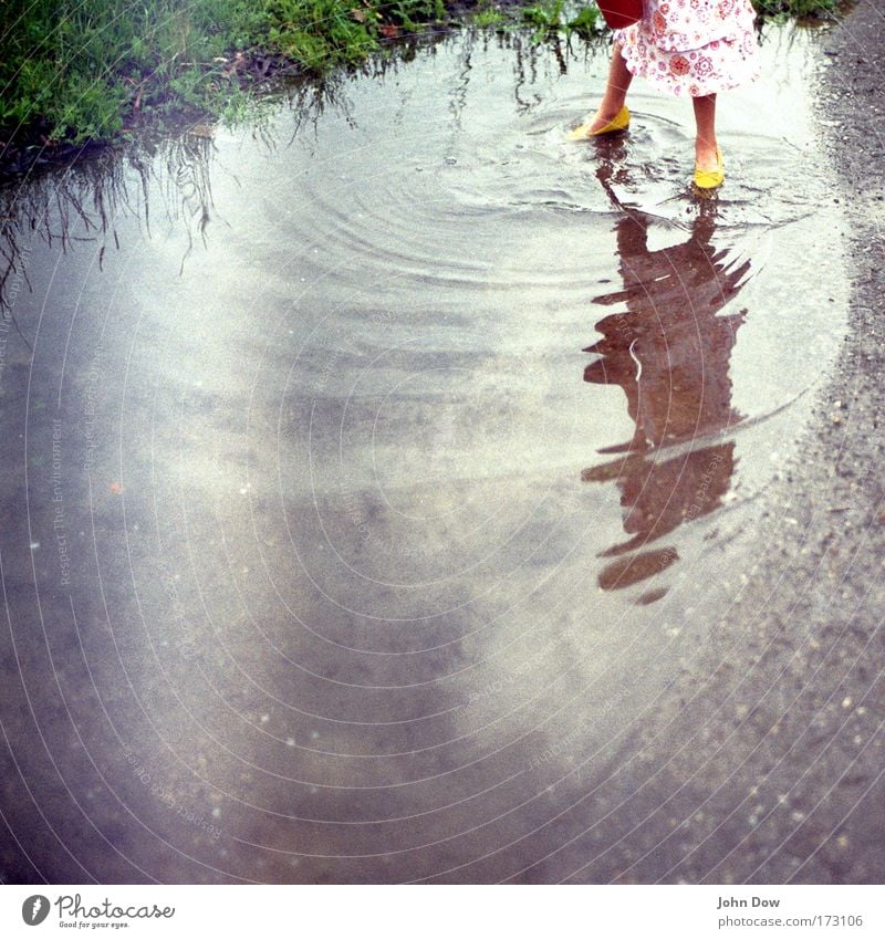 The water circles Structures and shapes Reflection Blur Leisure and hobbies Playing Girl Infancy 1 Human being Nature Water Grass Meadow Skirt Footwear Yellow