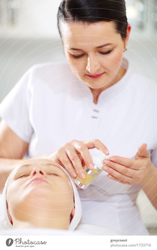 Female cosmetician is going to apply facial cosmetic during the procedure in the beauty treatment salon Skin Face Health care Medical treatment Spa Doctor