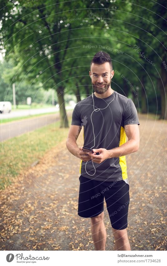 Attractive bearded man listening to music Lifestyle Face Summer Music Sports Telephone PDA Man Adults 1 Human being 18 - 30 years Youth (Young adults) Park