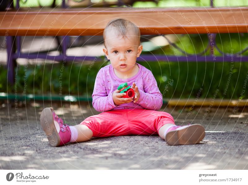 Small baby playing with toy sitting on the ground in the park and looking to the camera Joy Playing Summer Child Baby Girl Infancy 1 Human being 1 - 3 years
