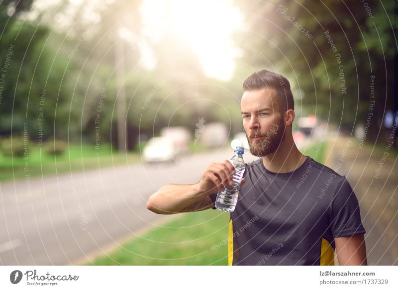 Young bearded man drinking bottled water Drinking Lifestyle Face Summer Man Adults 1 Human being 18 - 30 years Youth (Young adults) Warmth Beard Fitness