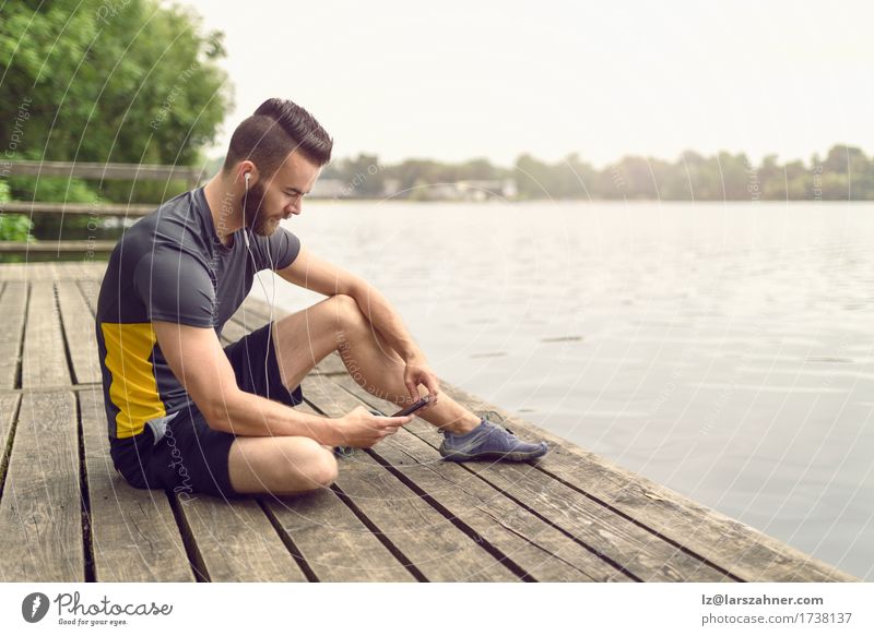 Attractive bearded young man relaxing on a wooden deck Lifestyle Face Relaxation Music PDA Masculine Man Adults 1 Human being 18 - 30 years Youth (Young adults)