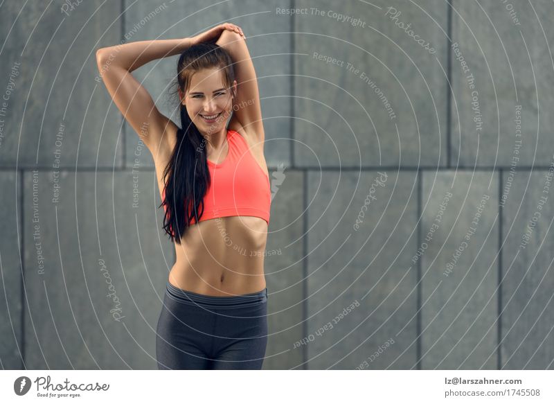 Brunette slim model in jeans and sports bra. Stock Photo by