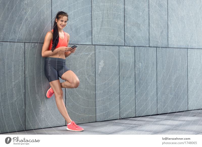 Sporty young woman checking her mobile Face Summer Telephone PDA Woman Adults 1 Human being 18 - 30 years Youth (Young adults) Warmth Brunette Fitness Smiling