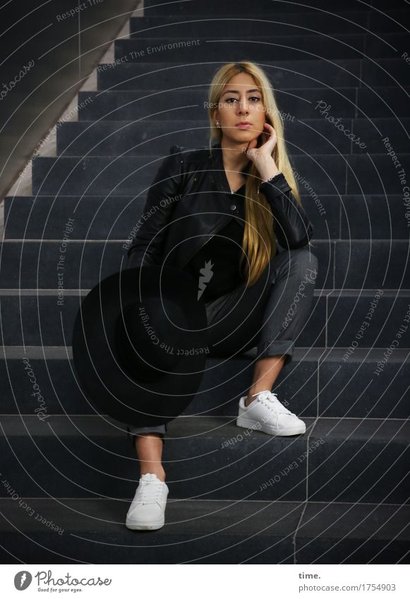 . Feminine 1 Human being Wall (barrier) Wall (building) Stairs Pants Jacket Sneakers Hat Blonde Long-haired Observe Think To hold on Looking Sit Wait Beautiful