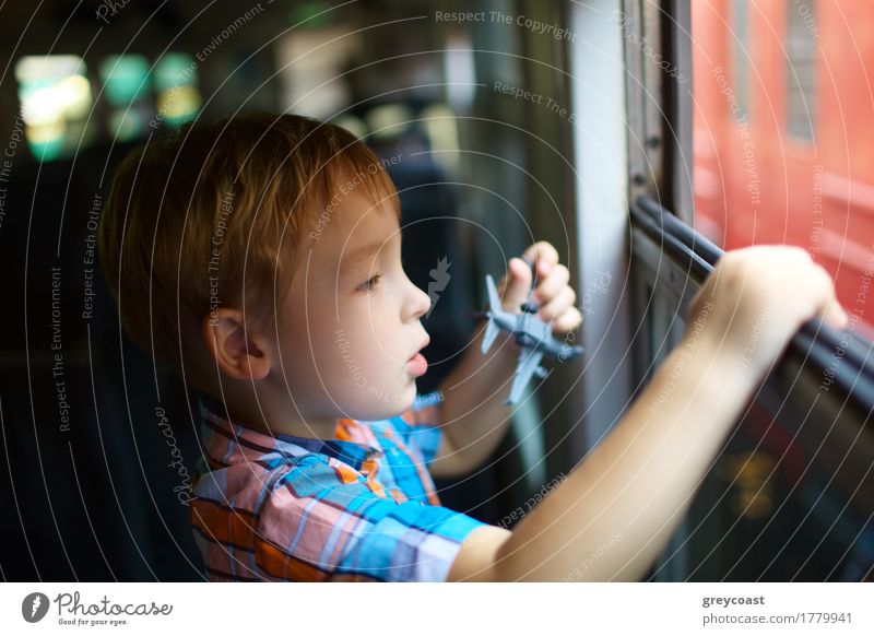 Curious little boy with toy plane looking out of open train window Vacation & Travel Trip Child Human being Boy (child) 1 3 - 8 years Infancy Railroad Blonde