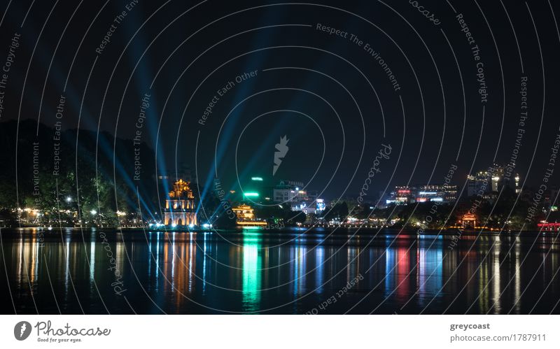 Hanoi view at night with illuminated Turtle Tower and Hoan Kiem Lake in city centre. Colorful lights reflecting in dark water Vacation & Travel Sightseeing