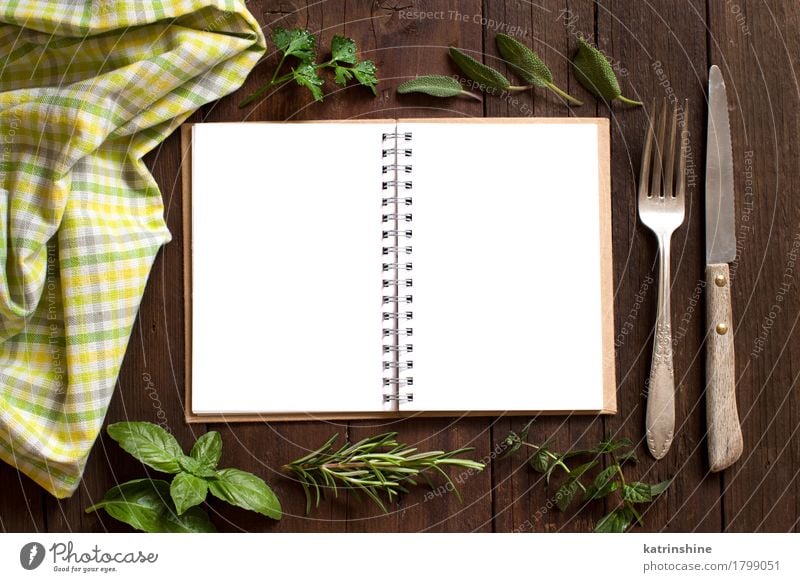 Blank cooking recipe book with fork, knife, herbs and napkin Herbs and spices Knives Fork Paper Brown Yellow Green background notebook empty frame Open