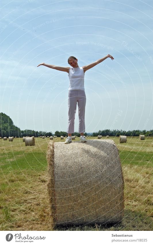 A little cuddle on the straw bale Field Meadow Bale of straw Woman Harvest Arm Young woman Full-length Isolated Image Bright background Summer Summery