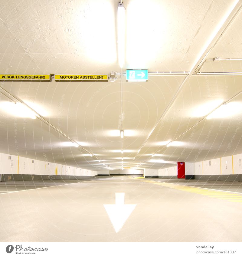 Turn off the engines! Town Deserted Parking garage Manmade structures Building Architecture Street Sign Road sign Line Arrow Stripe Emergency exit Red Bright