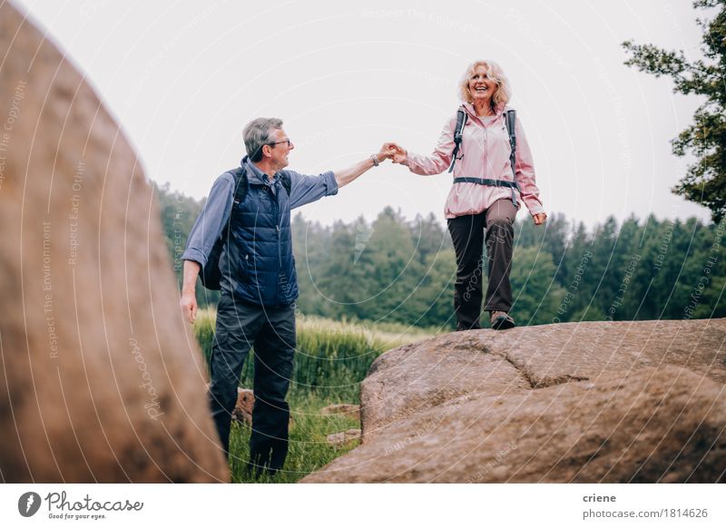 Senior Man helping his wife climbing up a rock on hike Lifestyle Joy Relaxation Leisure and hobbies Vacation & Travel Tourism Trip Adventure Hiking Woman Adults