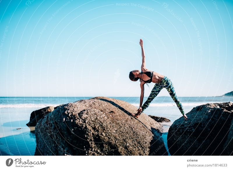 Fit African woman doing yoga exercise on rocks by the beach Lifestyle Relaxation Leisure and hobbies Beach Ocean Waves Sports Fitness Sports Training