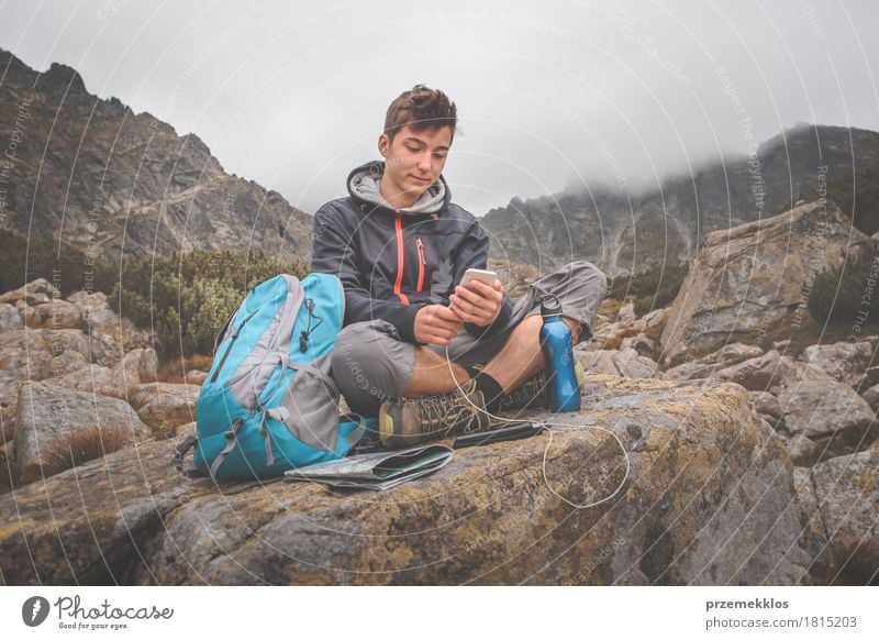 Boy resting on a rock and charging a mobile phone Bottle Lifestyle Leisure and hobbies Vacation & Travel Adventure Freedom Summer Mountain Hiking Boy (child) 1