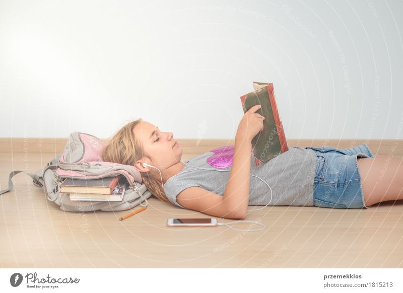 Schoolgirl reading a book in classroom Lifestyle Reading Education Classroom Schoolchild Academic studies University & College student Tool Girl