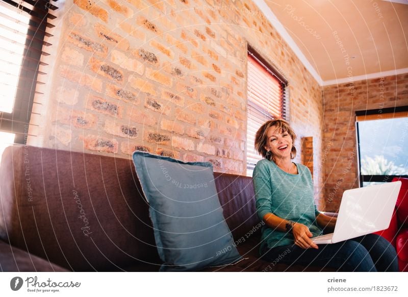 Woman having fun laughing with her laptop on couch at home Lifestyle Joy Work and employment Workplace Business Computer Notebook Technology Human being Adults