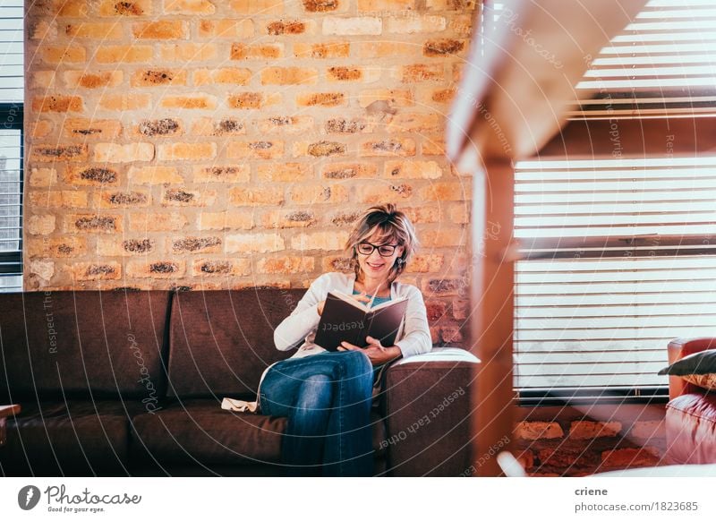 Caucasian woman reading a book in living room in modern house Lifestyle Joy Leisure and hobbies Reading Living or residing Flat (apartment)