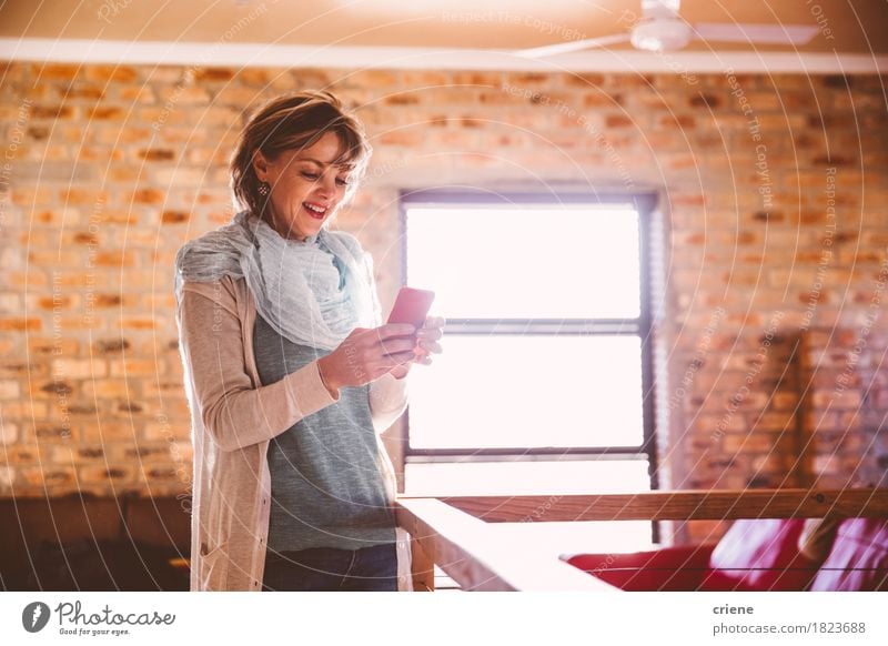 Caucasian happy woman standing in living room using mobil phone Lifestyle Joy Leisure and hobbies Living room Telephone Cellphone PDA Technology