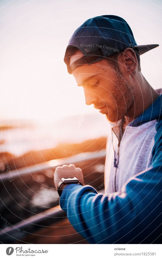 Young caucasian adult man looking on his smart watch at sunset Lifestyle Summer Sun Technology Internet Human being Young man Youth (Young adults) Man Adults