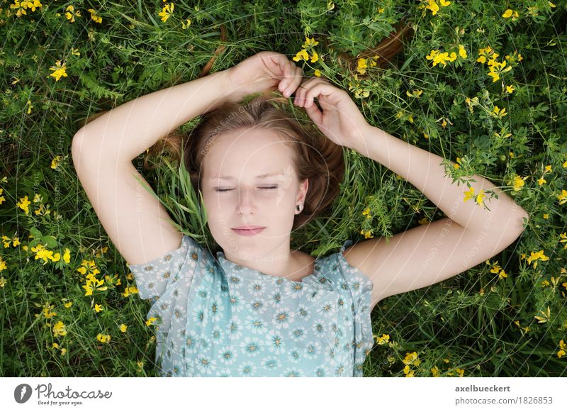 young blonde woman lies with closed eyes on a flower meadow Lifestyle Beautiful Well-being Relaxation Leisure and hobbies Summer Human being Feminine