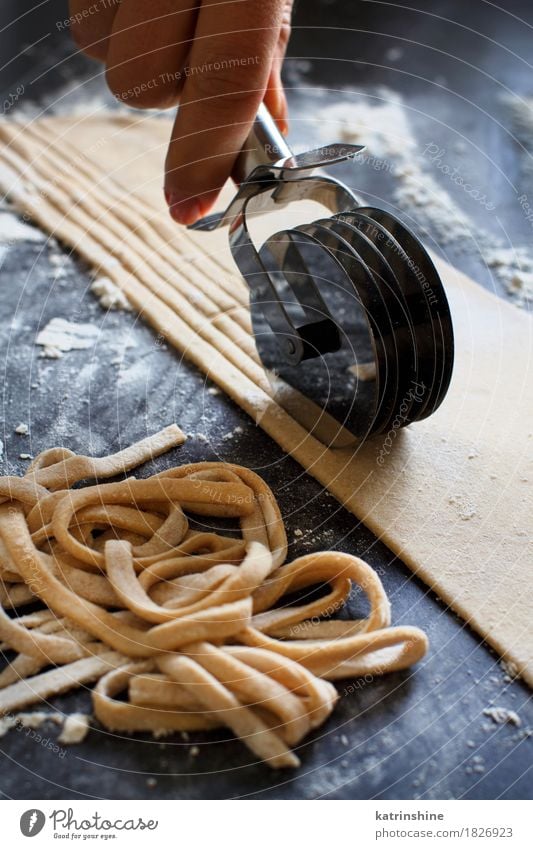 Making homemade taglatelle with a pasta rolling cutter Dough Baked goods Nutrition Italian Food Table Kitchen Tool Dark Fresh Tradition Ingredients manual