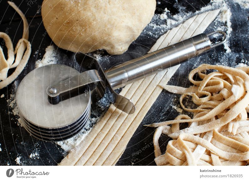 Making homemade taglatelle with a pasta rolling cutter Dough Baked goods Nutrition Italian Food Table Tool Make Dark Fresh Tradition Ingredients manual
