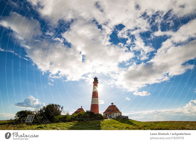 lighthouse Sky Clouds Sun Spring Summer Grass Hill House (Residential Structure) Lighthouse Tourist Attraction Large Blue Green Red White Colour photo