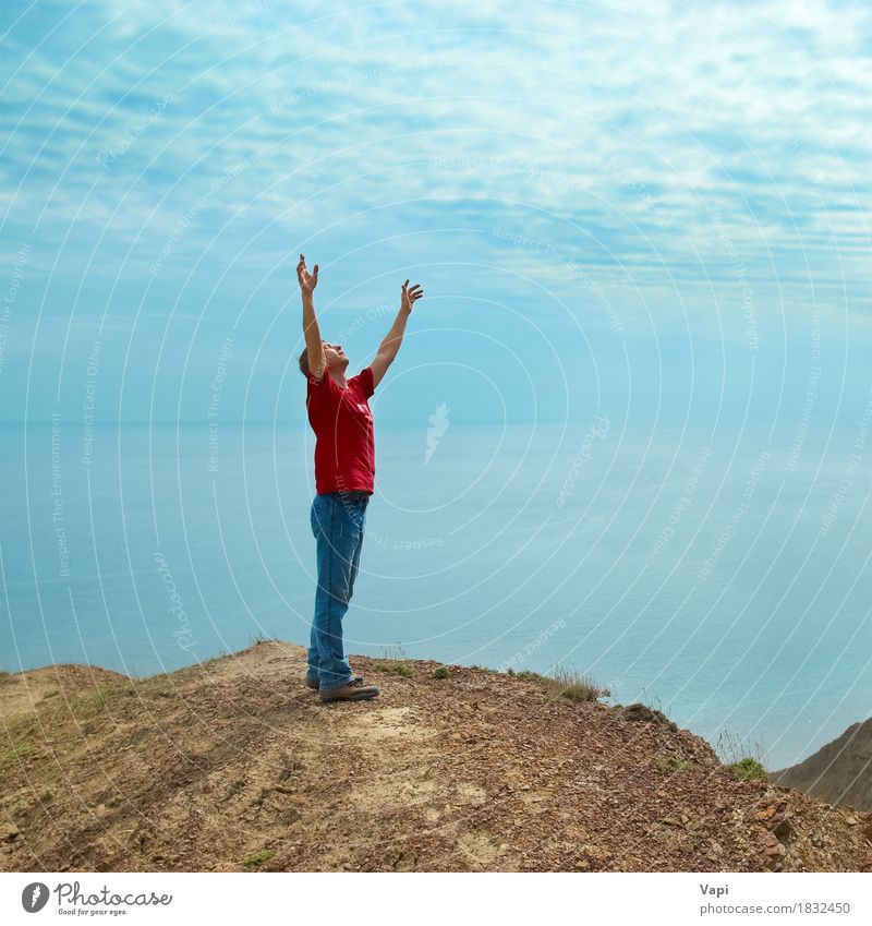 Happy man standing on cliff with hands up looking at the sea Lifestyle Joy Wellness Harmonious Well-being Relaxation Meditation Vacation & Travel Adventure