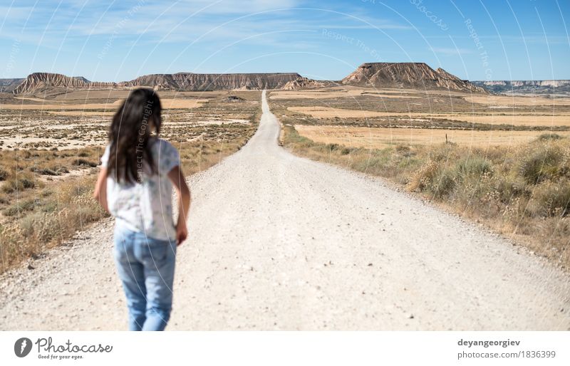 Woman with jeans walking on wild west Vacation & Travel Far-off places Freedom Sun Mountain Girl Adults Earth Sky Horizon Hill Street Lanes & trails Jeans