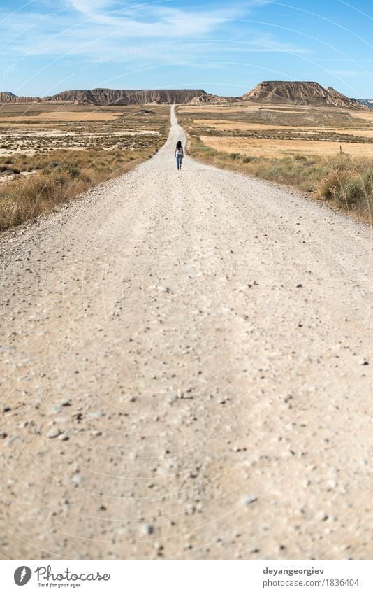 Woman walking on dirt road. Vacation & Travel Far-off places Freedom Sun Mountain Girl Adults Earth Sky Horizon Hill Street Lanes & trails Jeans Running Going