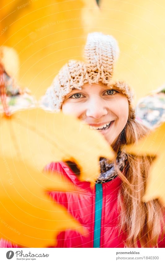 Smiling girl standing behind the blurred yellow autumn leaves Happy Beautiful Garden Girl Youth (Young adults) Face 1 Human being 8 - 13 years Child Infancy
