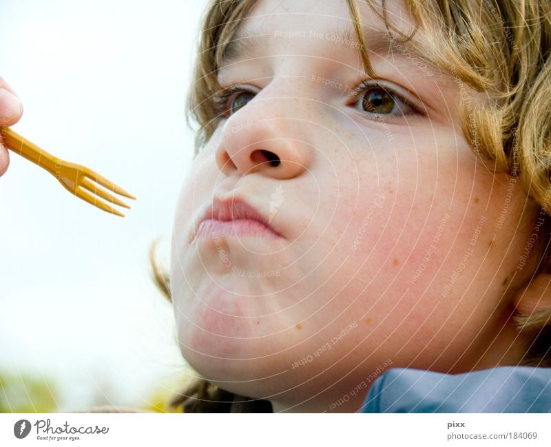 French fries days Colour photo Exterior shot Looking away Eating Child Schoolchild Human being Boy (child) Head 1 Blonde Curl Appetite Day Portrait photograph
