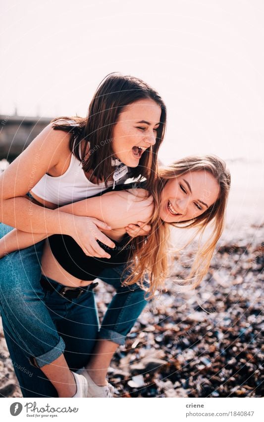 Happy Teenage Girls doing piggy back on the beach and having fun Lifestyle Joy Leisure and hobbies Vacation & Travel Tourism Adventure Freedom Summer Beach