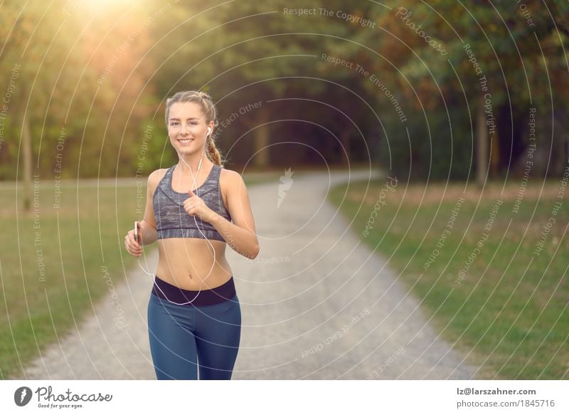 Woman jogging along a country road while listening to music Lifestyle Happy Summer Music Sports Jogging PDA Feminine Adults 1 Human being 18 - 30 years