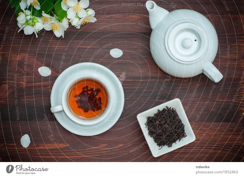 Black tea with jasmine in a white cup on a brown wooden table Herbs and spices Breakfast Dinner Asian Food Beverage Drinking Hot drink Tea Nature Flower Bowl