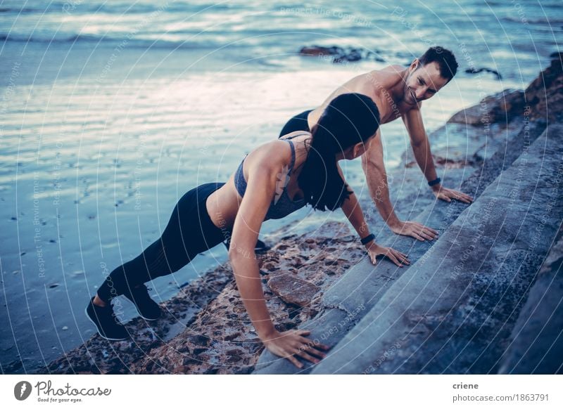 Young fit adult couple doing push up's together on staircas Lifestyle Wellness Leisure and hobbies Beach Ocean Sports Fitness Sports Training Sportsperson
