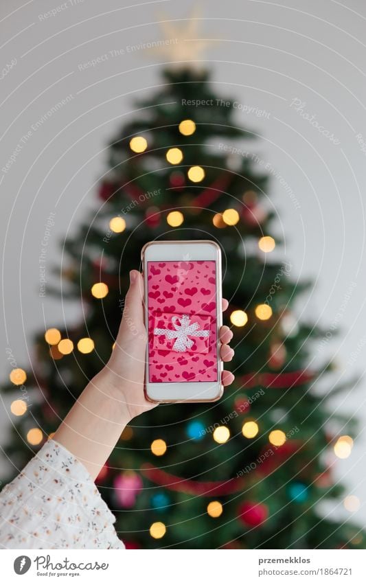 Online Christmas shopping using smart phone Shopping Decoration Telephone Cellphone PDA Screen Technology Girl Hand Tree blur Guest Gift Give Photography Pine