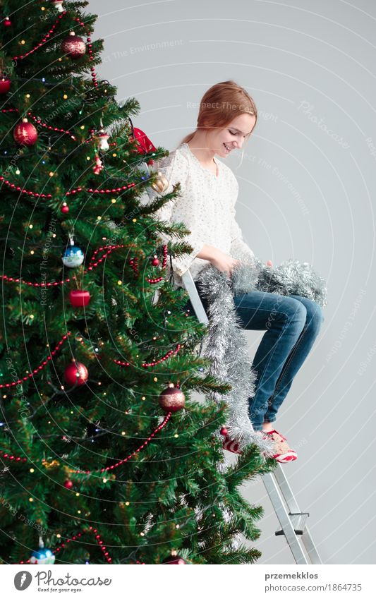 Young girl unwrapping Christmas decoration sitting on a ladder Lifestyle Joy Decoration Feasts & Celebrations Christmas & Advent Human being Child Girl 1