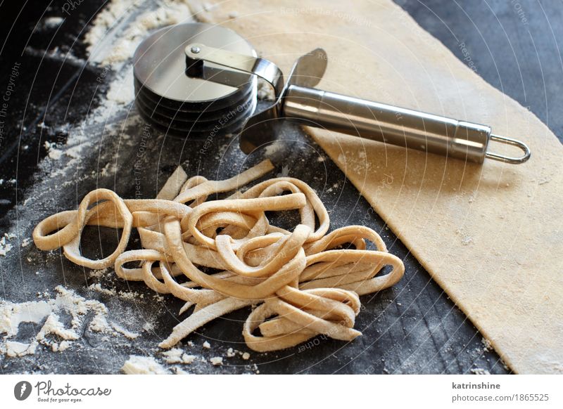 Making homemade taglatelle with a pasta rolling cutter Dough Baked goods Nutrition Diet Italian Food Table Make Dark Fresh Tradition Ingredients manual