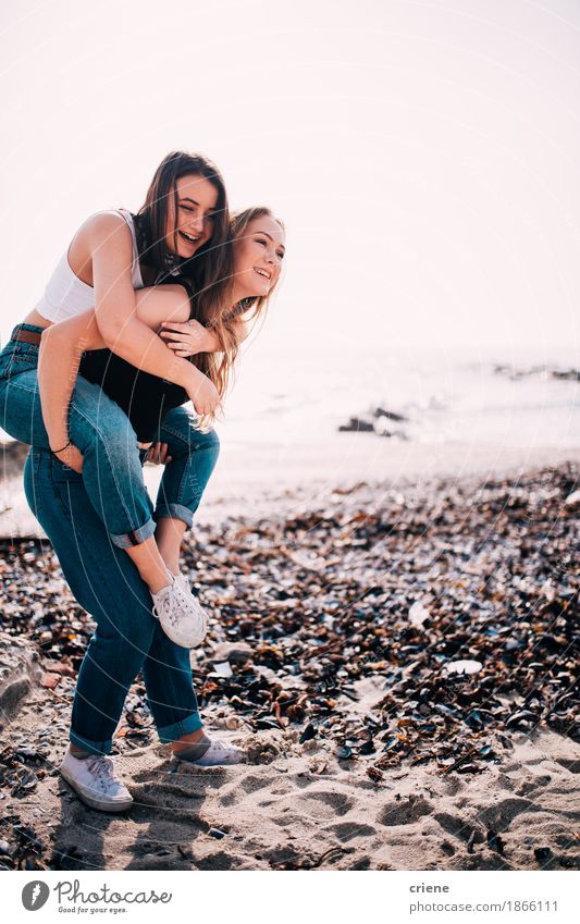 Happy Caucasian Teenage girls doing piggy back on the beach Lifestyle Joy Tourism Summer Ocean Girl Young woman Youth (Young adults) Sister Friendship Couple 2