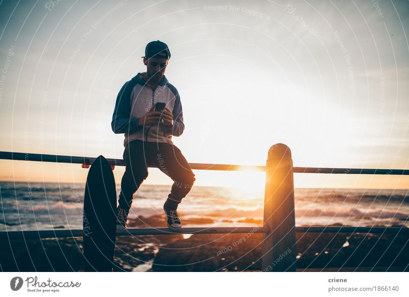Hipster guy sitting on railing browsing with his smart phone Lifestyle Leisure and hobbies Summer Telephone Cellphone PDA Technology Entertainment electronics