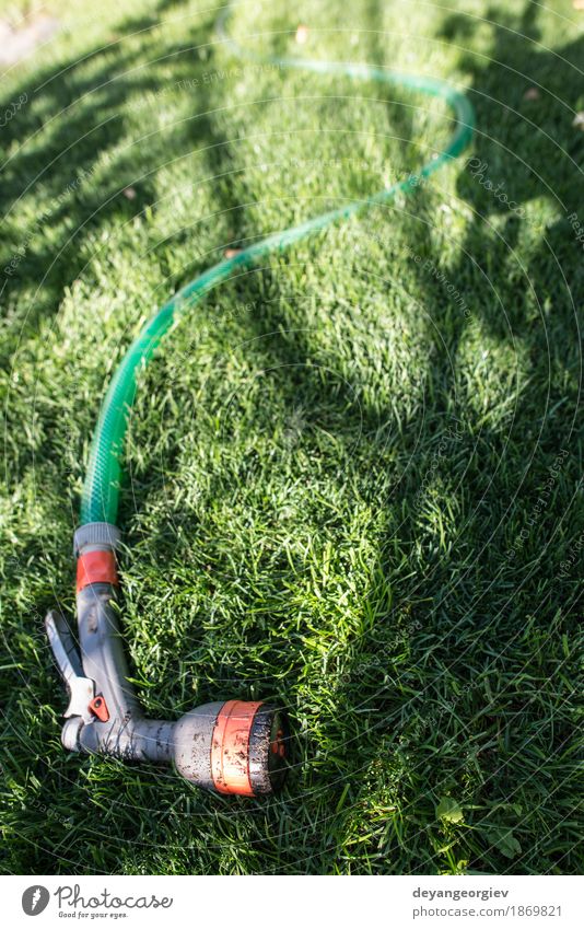 Garden hose and sprayer on green meadow Summer Gardening Tool Hand Environment Nature Grass Tube Wet Green Hose water sprinkler watering Lawn Irrigation Nozzle